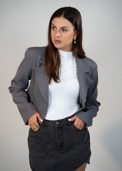 Crop Blazer Jacket for women in versatile gray. Featuring padded shoulders and a cropped design, this stylish jacket adds structure and sophistication to any outfit. Perfect for staying on trend and chic for any occasion