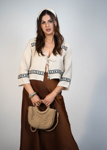 Trendy cream-colored front-tie top with 3/4 loose sleeves. Light and easy to style, featuring a chic front tie for added flair.