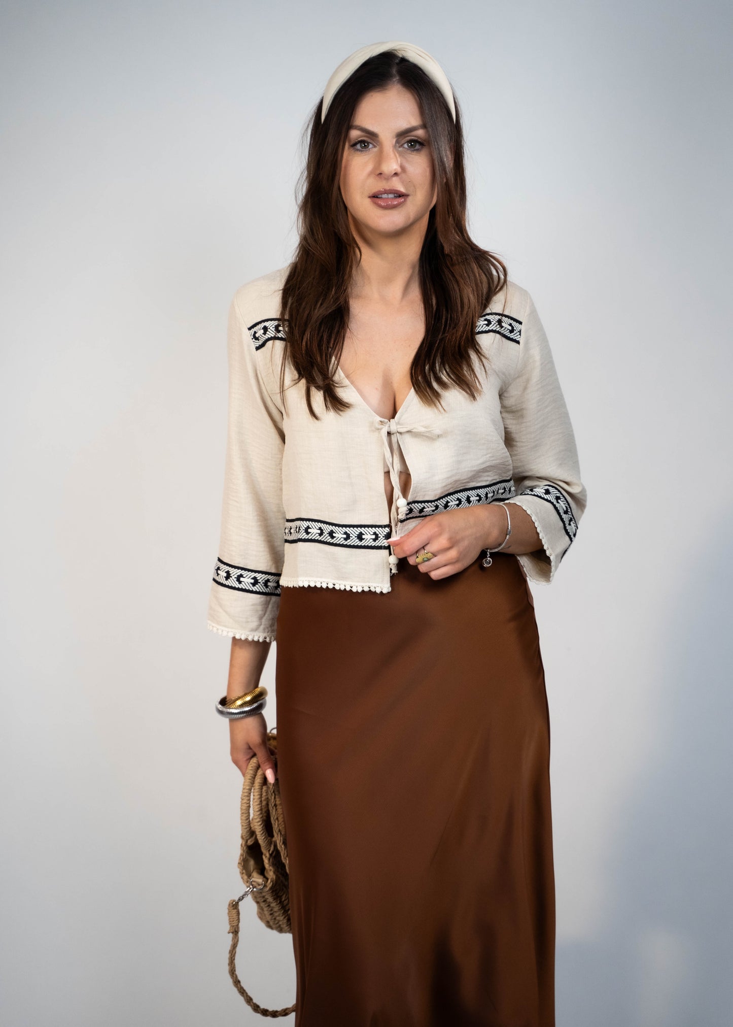 Trendy cream-colored front-tie top with 3/4 loose sleeves. Light and easy to style, featuring a chic front tie for added flair.
