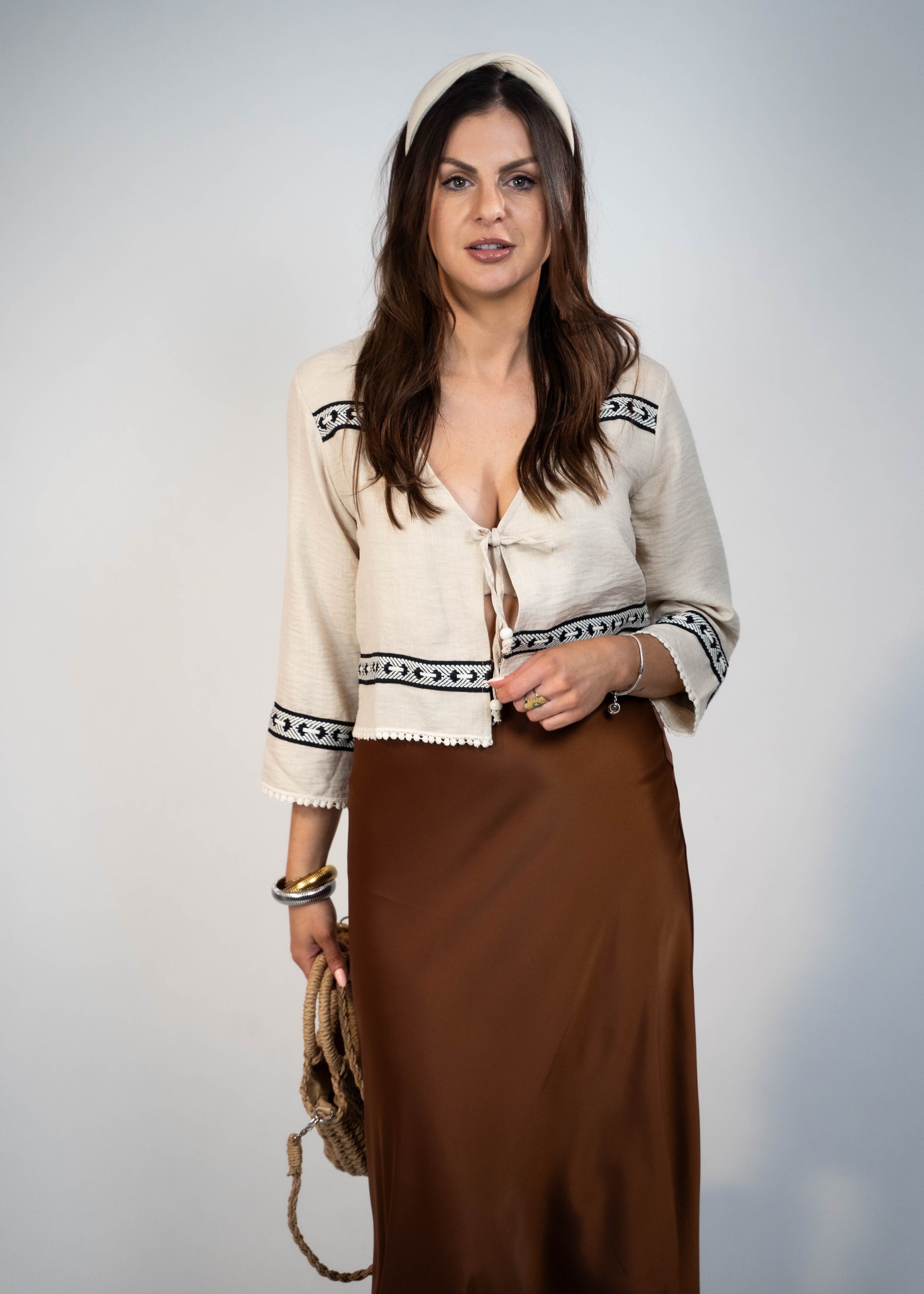 Trendy cream-colored front-tie top with 3/4 loose sleeves. Light and easy to style, featuring a chic front tie for added flair.