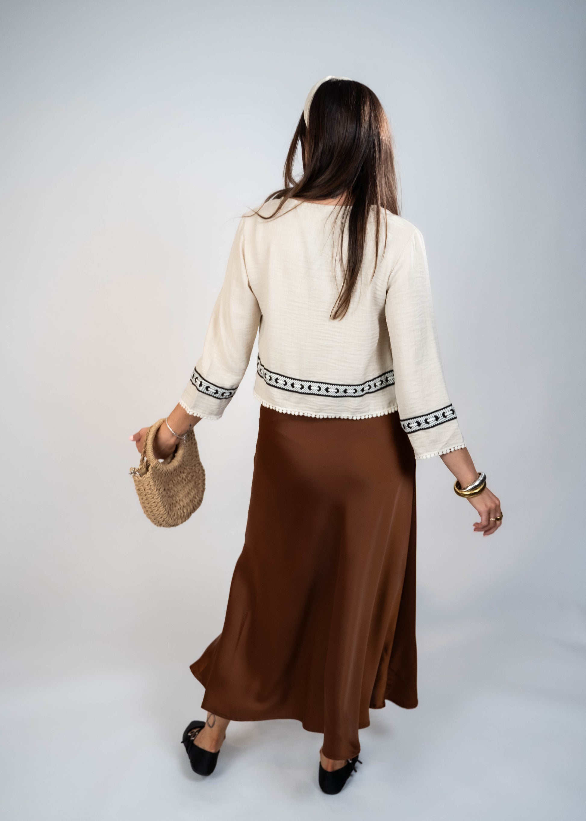 Trendy cream-colored front-tie top with 3/4 loose sleeves. Light and easy to style, featuring a chic front tie for added flair.