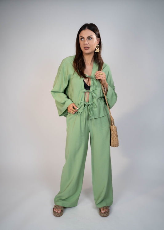 European style Palazzo Set featuring a flattering long-sleeve front-tie blouse and wide-leg palazzo pants. Made with breathable fabric, this elegant ensemble is perfect for any occasion. Elevate your wardrobe with this must-have set