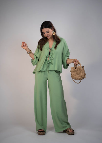 European style Palazzo Set featuring a flattering long-sleeve front-tie blouse and wide-leg palazzo pants. Made with breathable fabric, this elegant ensemble is perfect for any occasion. Elevate your wardrobe with this must-have set