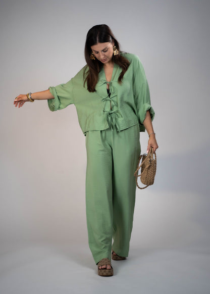 European style Palazzo Set featuring a flattering long-sleeve front-tie blouse and wide-leg palazzo pants. Made with breathable fabric, this elegant ensemble is perfect for any occasion. Elevate your wardrobe with this must-have set